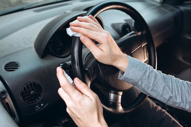 l'homme utilise un désinfectant en conduisant la voiture. Précautions pendant l'épidémie de coronavirus. homme au masque médical en voiture.