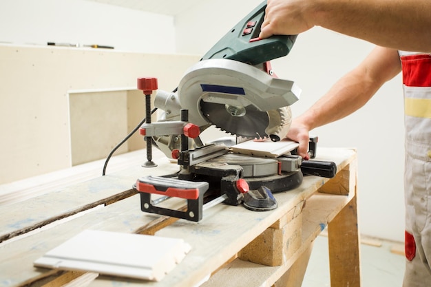 L'homme utilise un outil spécial pour couper des planches