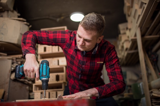 L'homme utilise une perceuse électrique dans l'atelier