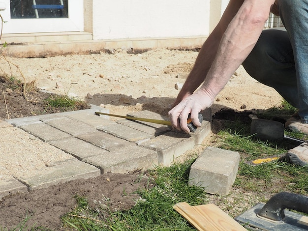 Un homme utilise une règle pour mesurer les briques.