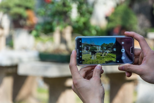 Photo l'homme utilise son téléphone portable à l'extérieur prendre une photo par téléphone portable dans le parc capturer le moment avec un smartphone dans mes mains