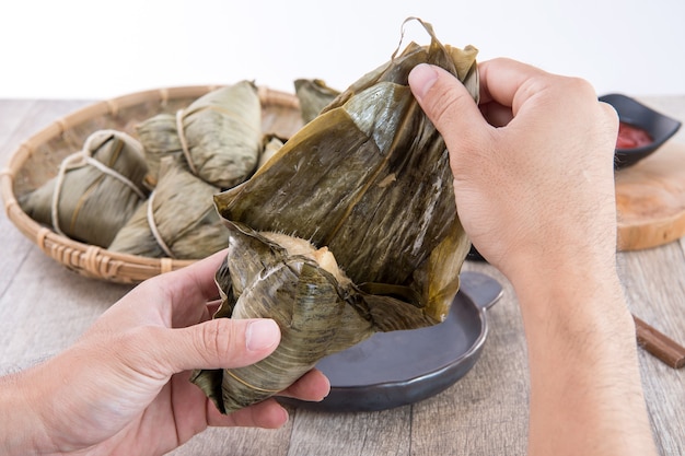 Un homme va manger du zongzi ou des boulettes de riz sur Dragon Boat Festival, cuisine traditionnelle asiatique