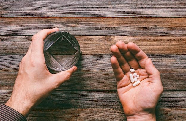 L&#39;homme va manger des pilules et des capsules et boire avec de l&#39;eau