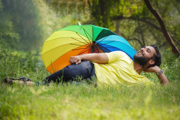 Homme en vacances avec parapluie en plein air