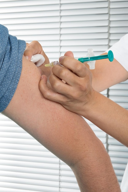 L'homme de la vaccination reçoit un vaccin par injection avec une seringue à l'hôpital par une infirmière médecin