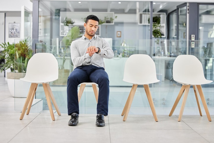 Photo homme veille et temps dans la file d'attente pour un entretien à la start-up avec la pensée dans la salle d'attense pour une réunion avec les ressources humaines personne veille et file d'attende pour une opportunité d'emploi embauchage ou recrutement avec des idées dans le hall au bureau
