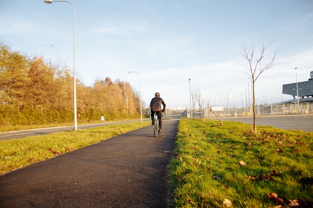 L'homme sur un vélo bleu dans la saison froide du matin se met au travail