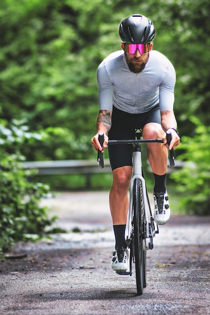 Un homme sur un vélo de course sur une route étroite