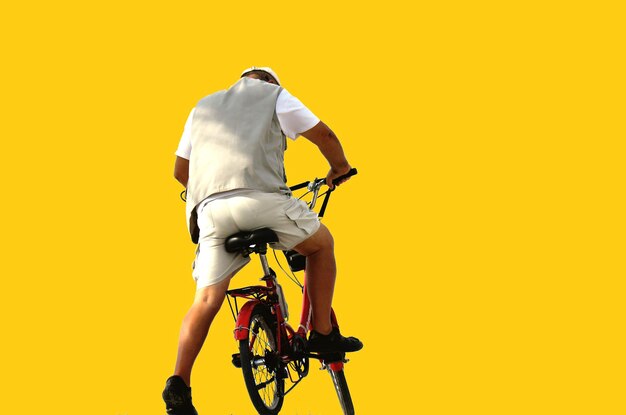 Photo un homme à vélo sur un fond jaune