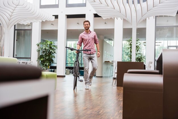 Homme avec vélo marchant au bureau