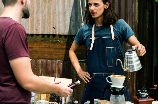 Homme vendant du café frais à des personnes au marché