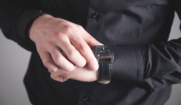 Homme vérifiant l'heure sur sa montre-bracelet.