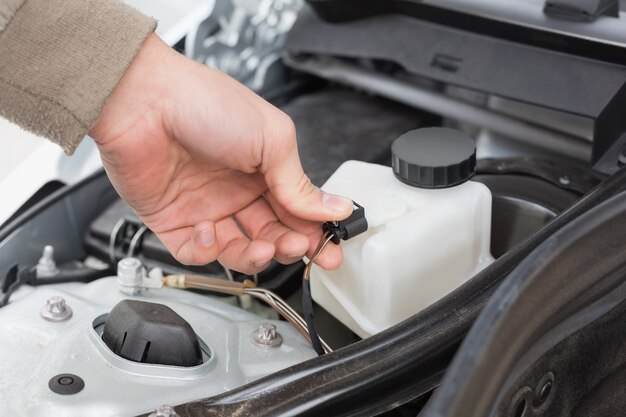 Homme vérifiant le moteur de sa voiture