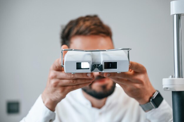 L'homme vérifie sa vision par un appareil électronique spécial à l'intérieur de la clinique