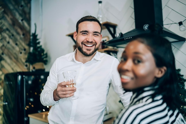 Homme avec verre de champagne parlant à un ami à la fête de Noël