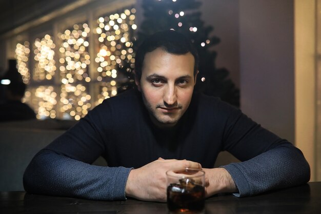 Homme avec verre de whisky dans le pub la nuit