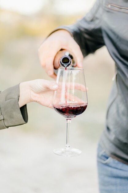 homme versant du vin rouge à une femme