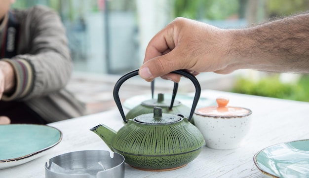 Homme versant un thé dans une tasse