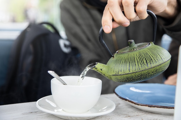 Homme versant un thé dans une tasse