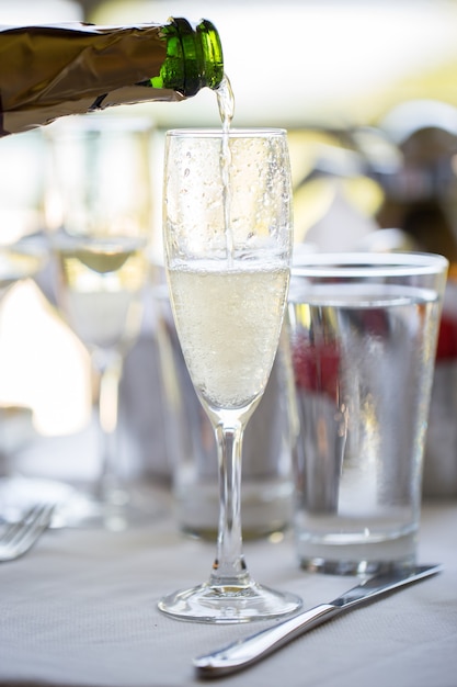 Un homme verse du champagne dans un verre