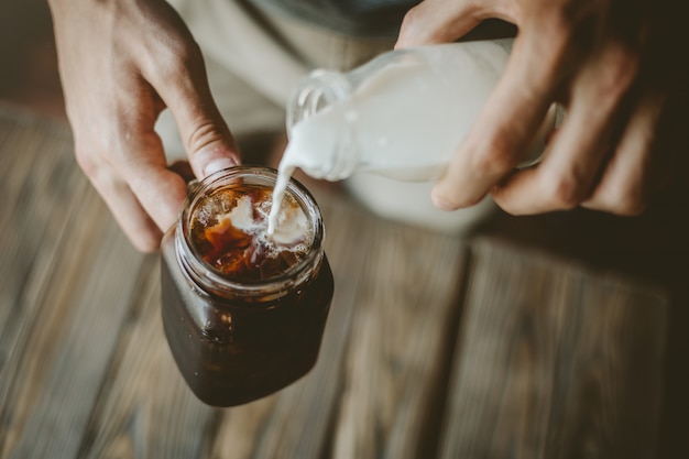 Homme, verser, lait, dans, café glacé