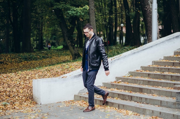 un homme en veste de cuir descend les escaliers