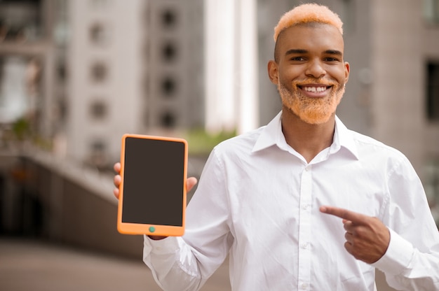 Photo un homme en vêtements blancs avec un gadget dans les mains