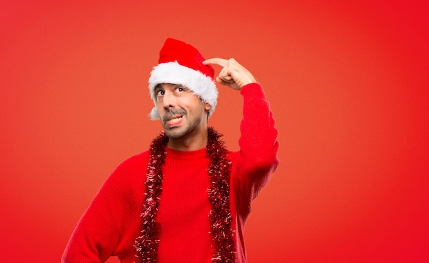 Homme avec des vêtements rouges célébrant les vacances de Noël ayant des doutes