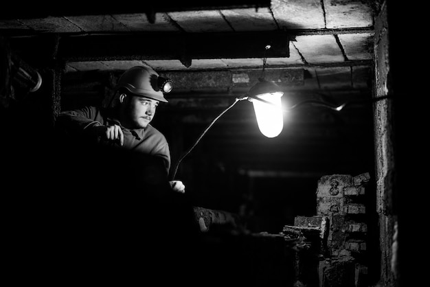 Un homme vêtu d&#39;une combinaison de protection et d&#39;un casque est assis dans un tunnel avec un album en feu