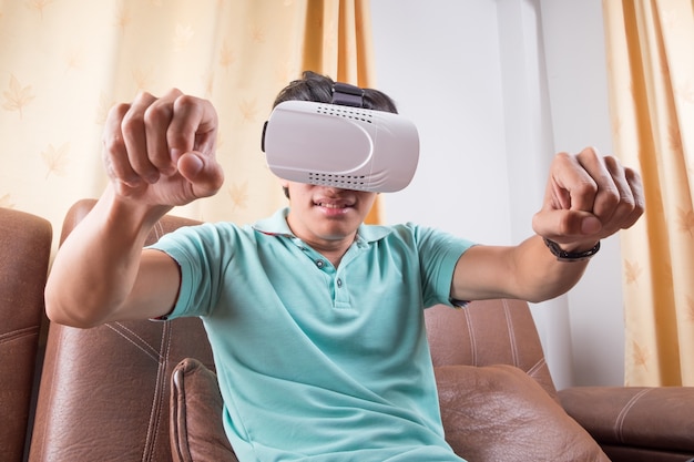 Homme vêtu de lunettes de réalité virtuelle en regardant des films ou en jouant à des jeux vidéo. La conception de casque vr est générique et pas de logos.