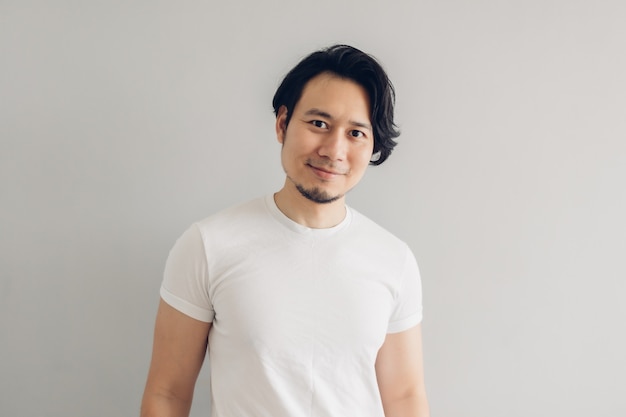 Homme de visage de sourire heureux avec de longs cheveux noirs et un t-shirt blanc