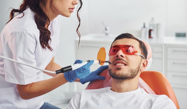 Homme visitant un dentiste en clinique Conception de la stomatologie