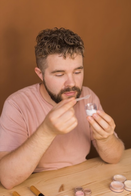 Homme vlogging sur le maquillage et les produits de beauté Homme tirant un tutoriel de maquillage Guy enseignant un tutoriel de maquillage en utilisant son concept de diversité de téléphone et de blogueur