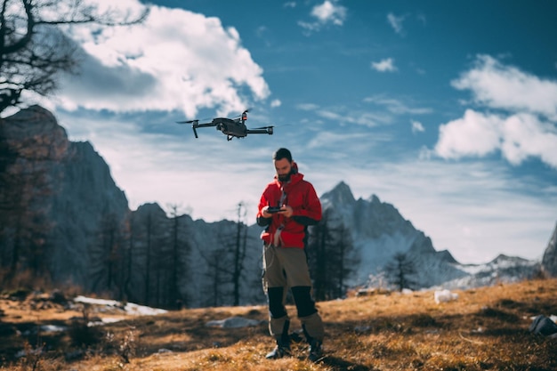 Un homme volant un drone contre des montagnes