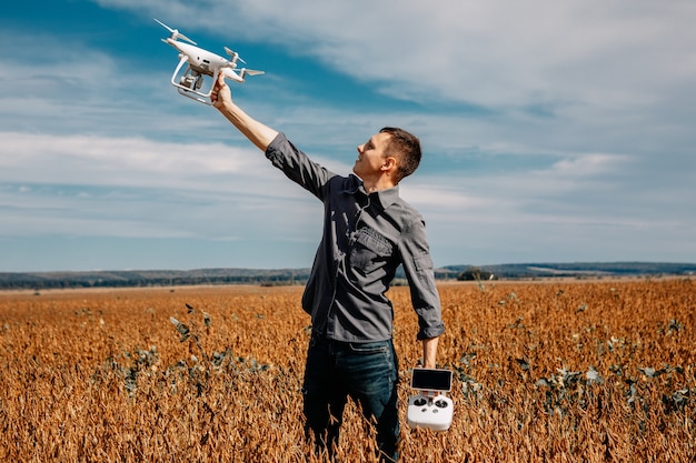 Homme volant un drone dans le champ jaune