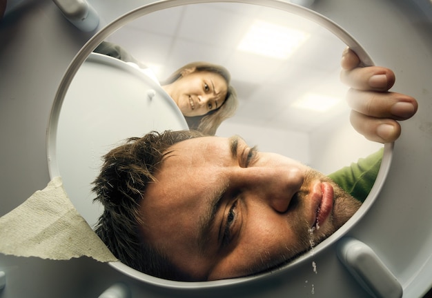 Homme vomissant dans la cuvette des toilettes