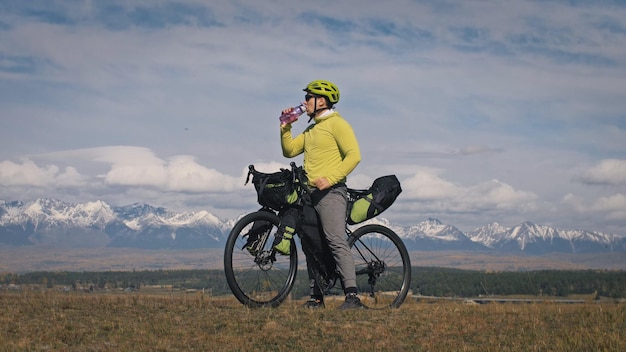 L'homme voyage en terrain mixte cyclotourisme avec bikepacking