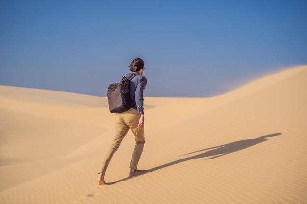 Un homme voyageant dans le désert Des dunes de sable et un ciel bleu par une journée d'été ensoleillée Voyage, aventure, concept de liberté Le tourisme rouvre après la quarantaine COVID-19