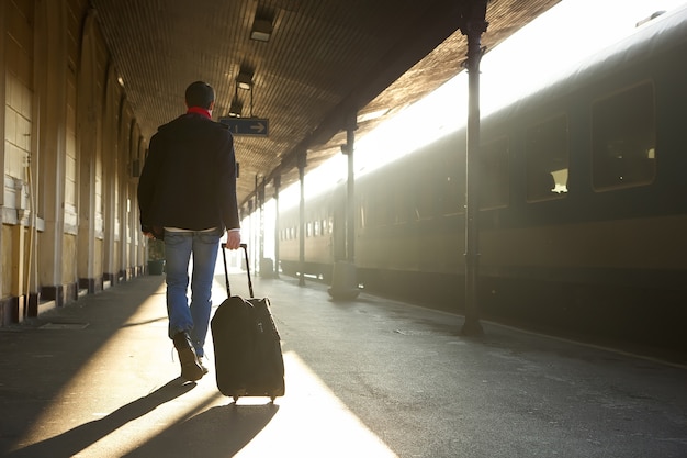 Homme voyageant avec un sac à la gare