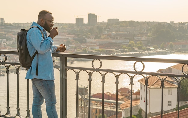 Homme de voyageur buvant du café sur le pont de Porto