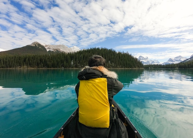 Homme voyageur en canoë sur l'île Spirit sur le lac Maligne avec les Rocheuses canadiennes aux beaux jours au parc national Jasper, Alberta, Canada