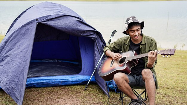 Homme de voyageur jouant de la guitare au camp