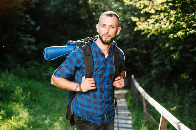 Un homme voyageur avec un sac à dos dans le bois