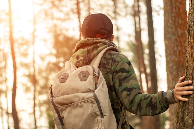 Homme de voyageur avec sac à dos debout près de la jungle tropicale