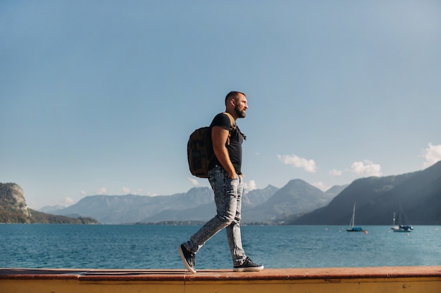 Homme voyageur avec un sac à dos sur le fond des montagnes alpines et des lacs