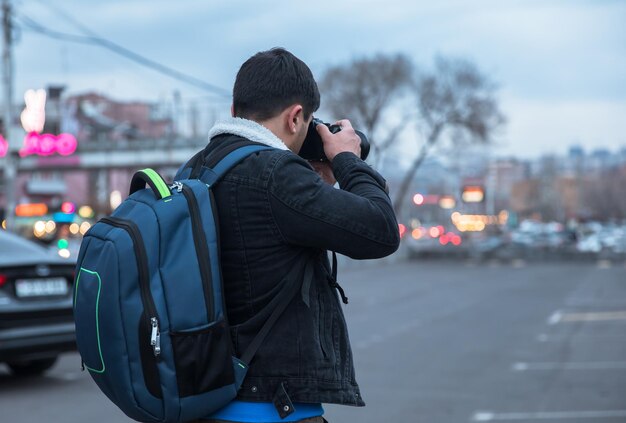 Homme voyageur tenant une caméra dans la rue