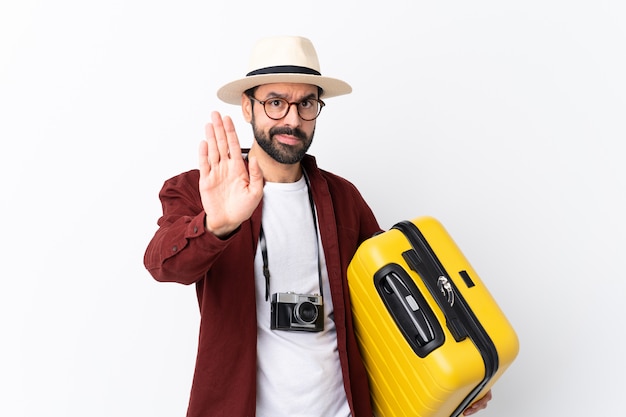 Homme voyageur avec valise sur mur isolé