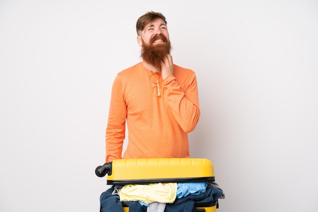 Homme voyageur avec une valise pleine de vêtements sur le mur blanc en pensant à une idée