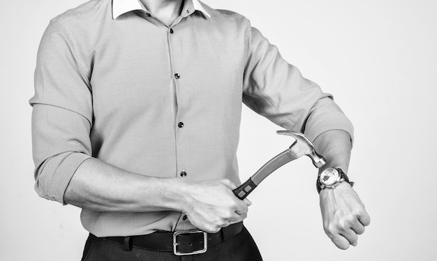 Homme vue recadrée pause montre-bracelet avec marteau battre l'horloge