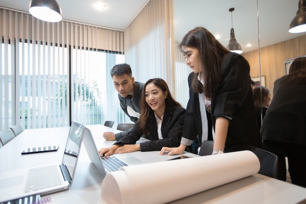 Hommes d&#39;affaires asiatiques et groupe à l&#39;aide de cahier pour les femmes de réunion et d&#39;affaires souriant heureux pour travailler